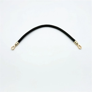 Detail of black PU leather handbag strap featuring elegant gold metal hooks and smooth finish