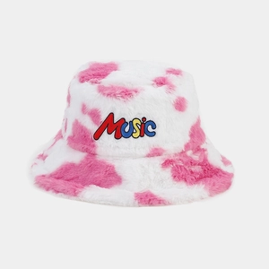 Detail of pink cow print bucket hat featuring colorful MUSIC embroidery on faux fur fabric