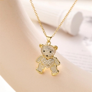 Gros plan d'un collier doré avec pendentif ours en peluche serti de cristaux scintillants