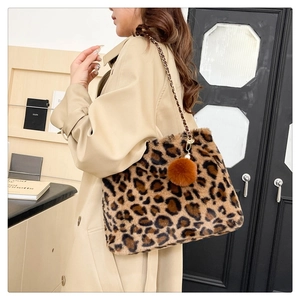 Leopard print plush shoulder bag with gold chain strap shown on model in trench coat