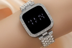 Macro shot of silver LED watch with square rhinestone bezel and sparkling strap on wrist