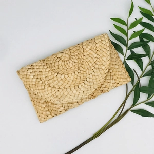 Detail of handmade corn husk straw envelope clutch bag with natural woven textures