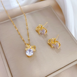 Detail of gold bow jewelry set featuring large round clear stones and pavé accents