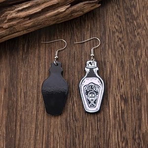 Gothic poison bottle acrylic earrings with skull motif on vintage wood surface