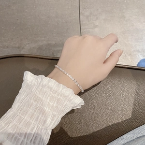 Elegant S925 sterling silver feather chain bracelet worn on wrist over leather