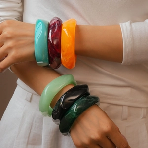 Minimalist geometric resin bangle with marble pattern shown on model in various colors