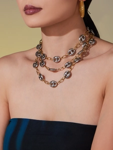 Ensemble collier multicouche bicolore or et argent et boucles d'oreilles portés par un mannequin