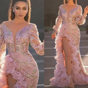 Pink sequined evening gown with mesh long sleeves, deep V-neck, ruffles, and high leg slit