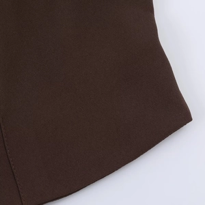 Détail macro du tissu marron foncé avec couture visible pour une chemise élégante
