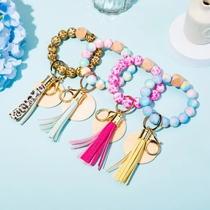 Detail of silicone and wood bead keychains with PU tassels in four assorted color combinations