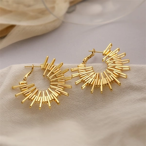 Elegant gold plated C-shaped geometric sunburst stud earrings on white fabric background