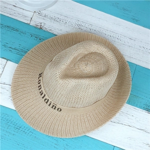 Macro shot of the tight beige straw weave and Ronaldino logo band on the brim hat