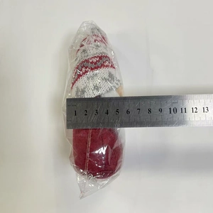 Détail d'un gnome de Noël de 5,5 cm de large emballé avec une règle de mesure graduée