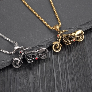 Detail showing vintage motorcycle pendants with red gems and metallic beaded chains