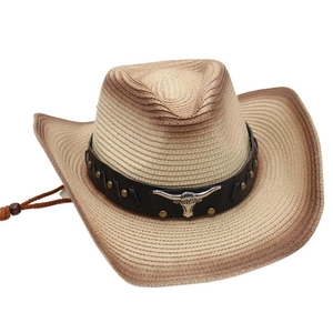 Detailed macro of woven straw cowboy hat featuring a silver bull head metal relief and studs