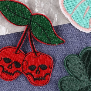Skull cherry and clover embroidered patches on denim background with high-density stitching
