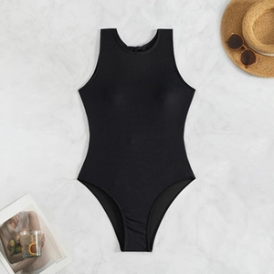 Solid black one-piece swimsuit with high cut design on white marble background