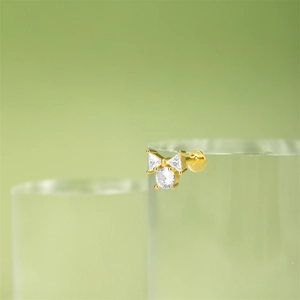 Detailed macro shot of gold heart stud earring with sparkling cubic zirconia on stand