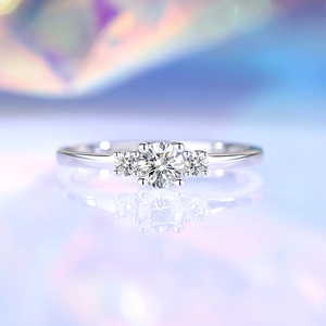 Classic S925 silver four-prong moissanite ring with three-stone design on violet background