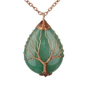 Macro detail of hand-wrapped copper wire Tree of Life on a green crystal drop pendant