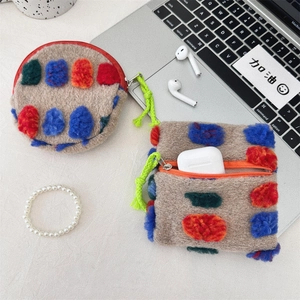 Macro detail of plush storage bags with colorful pom-poms and bright green lanyards