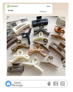 Detailed flat lay of matte claw clips in brown and beige tones on a textured background