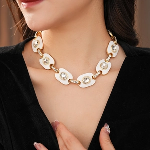 Détail d'un collier vintage doré avec strass étincelants porté par un mannequin