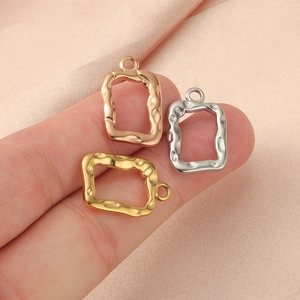 Detailed close-up of hollow rectangular metal charms in gold, silver, and rose gold