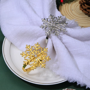 Close-up of gold and silver snowflake napkin rings with rhinestones on a festive table