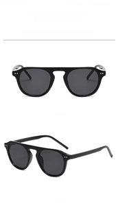 Detail of vintage round frame sunglasses with metal rivets and flat bridge design