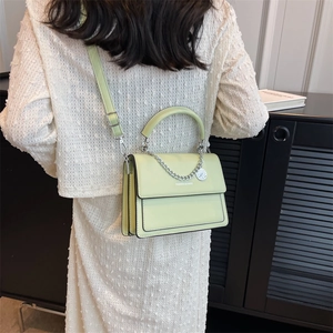 Fashionable light green square crossbody bag with chain strap and metal charm detail