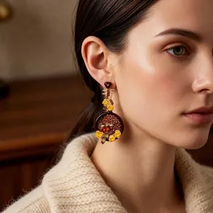 Vintage-style flower earrings with amber base and yellow petals worn by a model