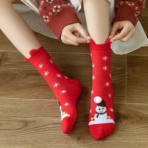 Festive red Christmas socks with snowman and snowflake patterns featuring cute pom-poms
