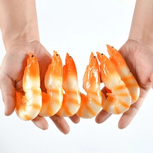 Macro detail of six realistic PVC peeled shrimp food models held in hands on white background