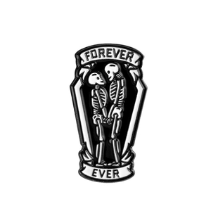 Detail of gothic enamel coffin brooch featuring white skeletons and Forever Ever text
