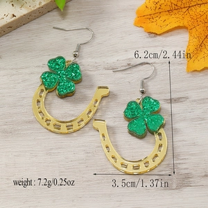 Detail view of St. Patrick's Day horseshoe earrings with green glitter shamrock accents