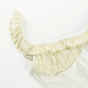 Detail of ruffled neckline and fine stitching on creamy white pleated slim vest top