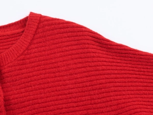 Close-up of bright red knitted sweater fabric with fine vertical ribbed texture