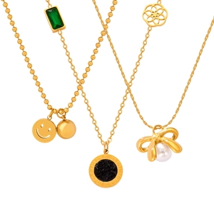 Three elegant gold-plated necklaces with charms including a green gem and a smiling face