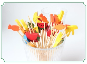 Bamboo fruit picks with colorful fruit tops like strawberry and pineapple in a glass jar