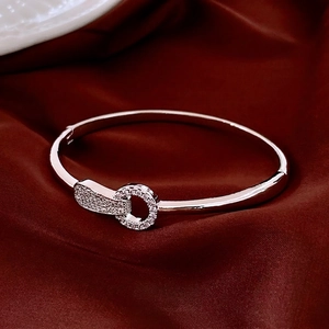 Bracelet jonc argenté poli avec cercles entrelacés sertis de strass sur soie rouge