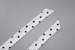 Close-up of black polka dot silk scarf with high quality stitching and texture