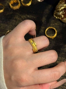Close-up of vintage gold ring featuring star and sun engravings with zircons