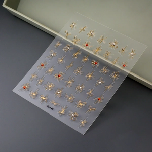 5D gold bow and floral nail art stickers with red crystal rhinestones and adhesive backing