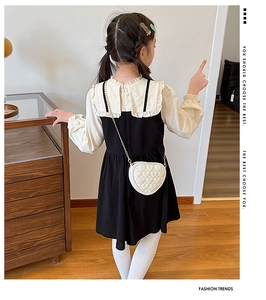 Detail of white heart-shaped quilted crossbody bag with golden chain strap for girls