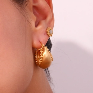 Macro view of 18K gold plated hoop earrings with bead trim and daisy studs on model