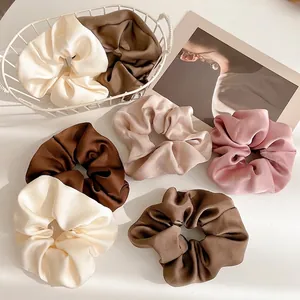 Set of minimalist satin scrunchies in cream, brown, and pink with premium silk-like luster