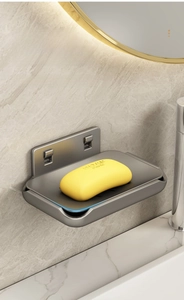 Detail of grey aluminum double-layer soap dish with rounded edges on marble wall
