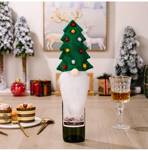 Detailed view of Christmas tree wine bottle cover with long white beard and colorful pom poms