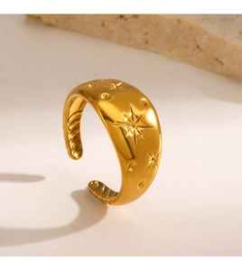 Close-up of golden wide star-engraved open ring with polished finish on stone